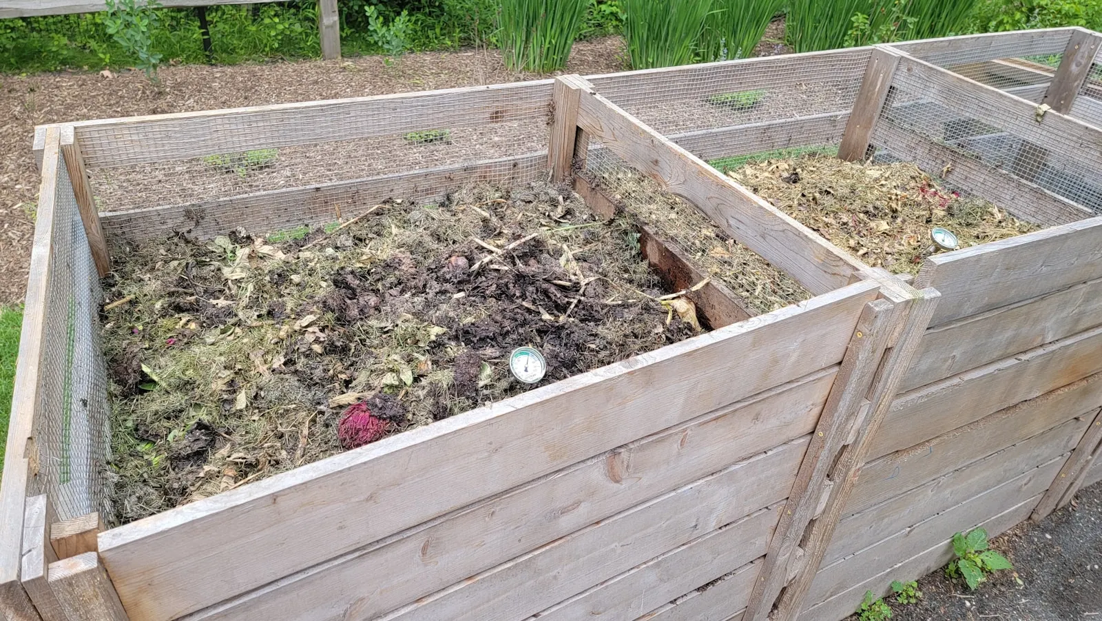 Wooden compost bins filled with soil and garden material